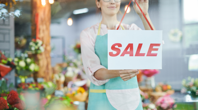 A female business owner hangs a 