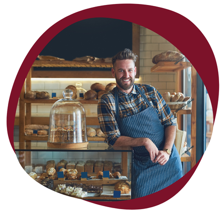 small business owner leaning on a counter in a bake shop
